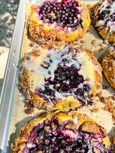 blueberry muffins with icing and powdered sugar are on a tray