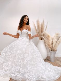 a woman in a white wedding dress posing for the camera