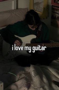 a person sitting on a bed with a guitar in their lap and the caption reads, i love my guitar