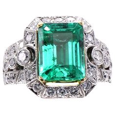 an emerald and diamond ring with white diamonds