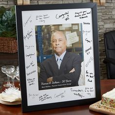 a table with a piece of cake on it and a framed photo next to it