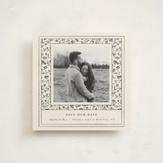 an old fashioned photo frame is mounted on the wall above a couple's head