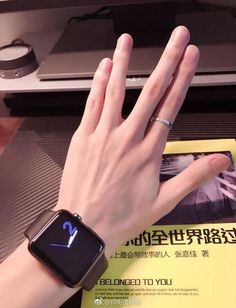 a woman's hand with an apple watch on her wrist, in front of a computer