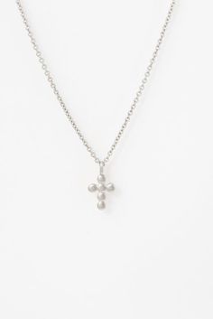 front view of the mini beaded cross necklace in white gold on a white canvas Beaded Cross Necklace, Simple Reminders, Beaded Cross