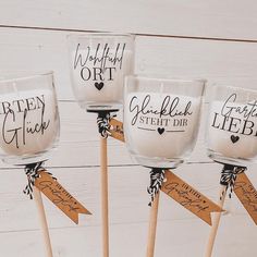 three wine glasses with wooden sticks in front of white wood planks and tied around them