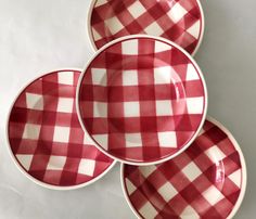 three red and white checkered plates sitting on top of each other