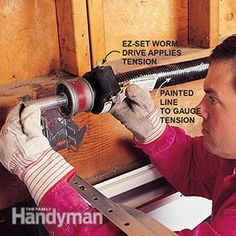 a man working on the side of a wooden wall with tools attached to his hand