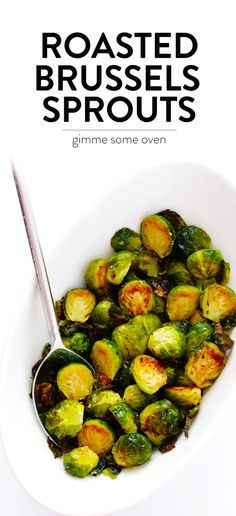 roasted brussel sprouts in a white bowl with a spoon on the side