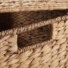 an empty wicker basket with handles on the bottom is shown in close up view