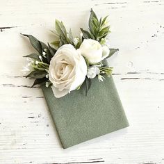 white flowers are placed on top of a green napkin