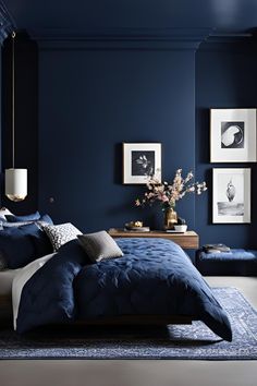 a bedroom with dark blue walls, white and gray bedding and pictures on the wall