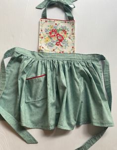 a green purse with a flowered design on the front, and a small patchwork bag in the back