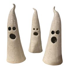 three white ceramic candlesticks with holes in them