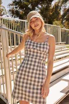 Gingham plaid mini dress. Sweetheart neckline. Fitted bodice. Sleeveless with adjustable cami straps. Open back with smocked elastic straps. A-line skirt. Invisible zipper side closure. High waist. Thigh length. Fitted silhouette. 100% Cotton. Imported. Designed in LA. Model wears size S. Fitted Dress With Adjustable Straps For Picnic, Fitted Gingham Plaid Mini Dress, Sleeveless Gingham Plaid Fitted Dress, Fitted Plaid Sundress For Picnic, Fitted Mini-length Plaid Dress For Picnic, Fitted Gingham Mini Dress For Picnic, Fitted Gingham Mini Dress For Picnics, Plaid Mini Sundress For Picnic, Fitted Sleeveless Plaid Dress For Day Out