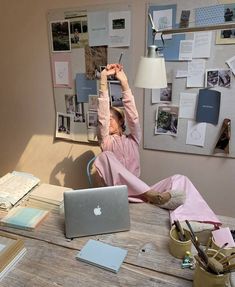 a woman sitting at a desk with her laptop and cell phone in front of her