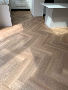 an image of a kitchen setting with wood flooring and white cabinets in the background