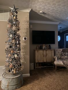 a living room with a christmas tree in the corner and other decorations on the floor