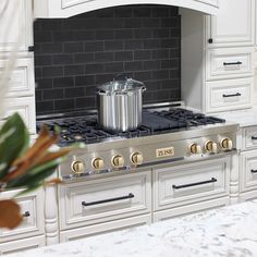 a stove top oven sitting in a kitchen next to a vase with flowers on it