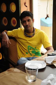 a man sitting at a table in front of a plate and glass with water on it