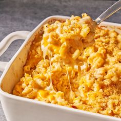 a spoonful of macaroni and cheese being lifted from a casserole dish