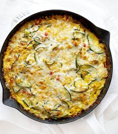 a casserole with zucchini and cheese in a cast iron skillet