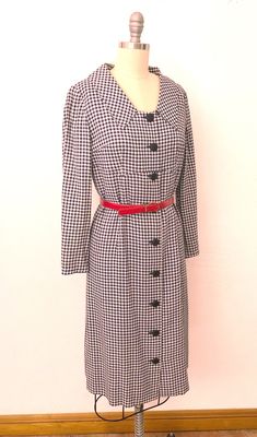 "Vintage 1960's classic shirtdress. Woven white and navy checkered pattern. Enlarged collar, empire waist with a working buttondown front. Slim darted sleeves. Inside is completely lined with dark navy acetate. Wear belted or not - comes with a red belt. Buttondown front has additional snaps on the waist. Handmade and in excellent pre-worn condition. Best fits a size medium. --- M E A S U R E M E N T S --- Measurements are taken flat and doubled. Fits like medium Bust: 36\" Waist: 34\" Hips: 36\ Classic Fitted Plaid Dress, Fitted Retro Plaid Dress For Fall, Gingham Dress With Button Closure For Work, Fitted Plaid Dress With Buttons For Fall, Fitted Plaid Dress For Work, Gingham Dresses With Button Closure For Work, Classic Business Dresses For Fall, Classic Fall Business Dresses, Collared Plaid Dress For Work