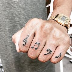 a man with tattoos on his fingers and wrist