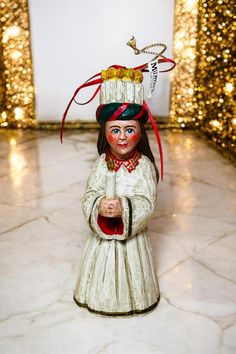 a ceramic figurine with a hat on it's head is standing in the middle of a room