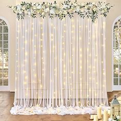 a white wedding backdrop with flowers and candles