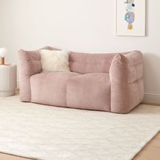 a pink couch sitting on top of a white rug