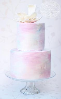 a three tiered cake with white flowers on top