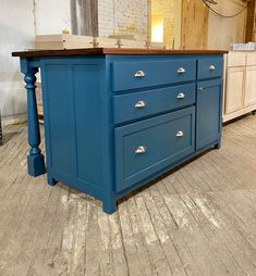 a blue kitchen island with drawers on it