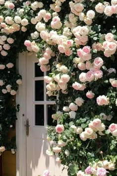 a white door surrounded by lots of pink flowers