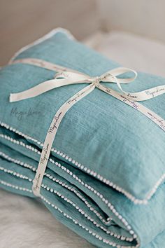 a stack of blue pillows wrapped in white ribbon