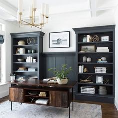 a living room with bookshelves and a rug on the floor in front of it