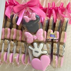 some cookies are in the shape of hats and bow ties with pink bows on them