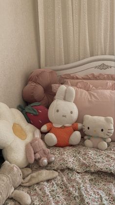 several stuffed animals sitting on top of a bed