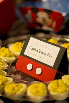 a plate with deviled eggs on it and a disney mouse place card in the middle