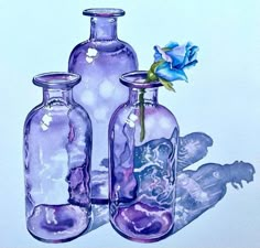 three glass vases with flowers in them