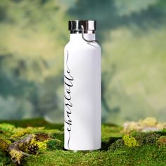 a white water bottle sitting on top of green moss