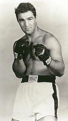 an old black and white photo of a man wearing boxing gloves with his hands on his hips