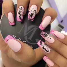 a woman with pink and black butterflies on her nails holding a round object in her hand