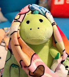 a stuffed animal with a blanket around it's neck