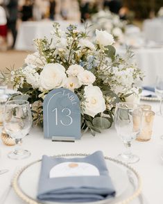 the table is set with white flowers and blue napkins for an elegant wedding reception