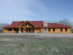 a large log house with a red roof