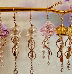 Add a touch of the ocean to your jewelry collection with these stunning Jelly Fish Dangle Earrings. These unique earrings feature intricately designed jellyfish charms that will sway and shine with every movement. Perfect for anyone who loves marine life or wants to add a whimsical touch to their outfit. These earrings are sure to make a splash and are a great gift for any ocean lover. Clear Dangle Jewelry For Party, Handmade Whimsical Clear Jewelry, Whimsical Handmade Clear Jewelry, Adjustable Iridescent Dangle Jewelry, Whimsical Adjustable Iridescent Jewelry, Clear Dangle Pierced Jewelry, Whimsical Jewelry With Dangling Charms For Party, Unique Clear Drop Earrings, Whimsical Nickel-free Jewelry For Party