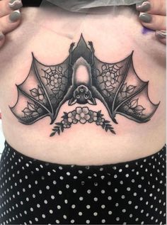 a woman with a bat tattoo on her stomach