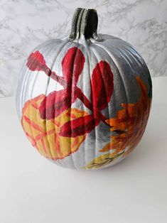 a painted pumpkin sitting on top of a white table next to a marble countertop