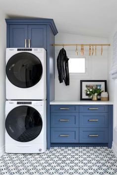 a washer and dryer in a laundry room with blue cabinets