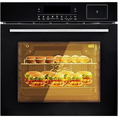 an oven with several sandwiches and cupcakes in the door, one on each shelf